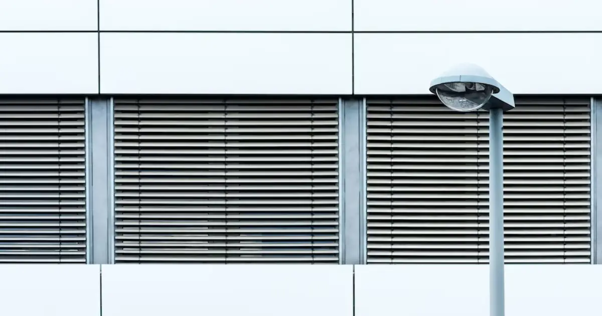 Person using a remote to control motorized blinds in a modern room